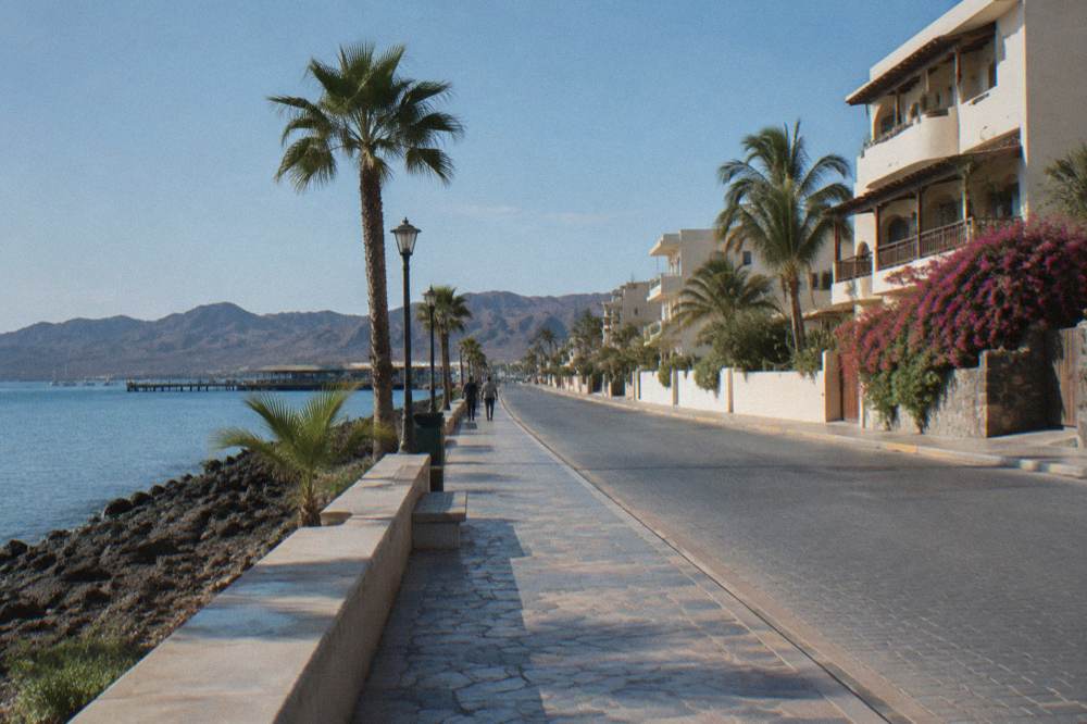 Open waterfront road along the bay heading north from La Paz toward Costa Baja